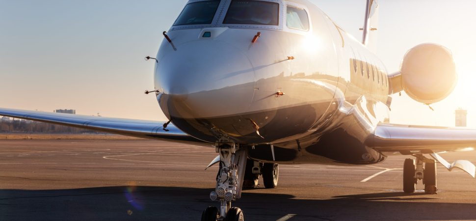 Scenic front view of a private jet plane parked on the airport taxiway.